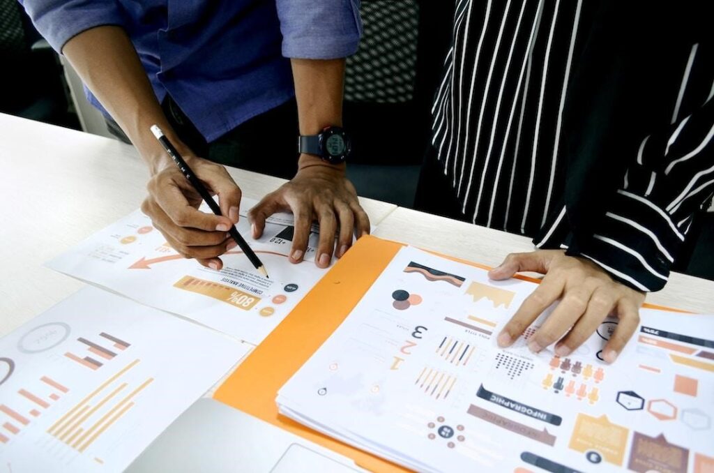 Two business professionals reviewing various sets of data to include in a parallel coordinate plot.